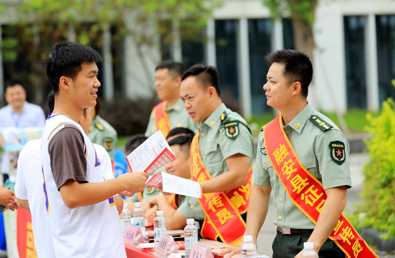 在广西柳州市融安县高级中学，征兵工作人员向学生宣传讲解征兵政策。谭凯兴摄